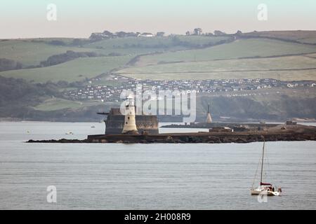 The historic Breakwater on Plymouth Sound against a backdrop of the hills of the South Hams with holiday chalets at at Bovisands. Plymouth Breakwater Stock Photo