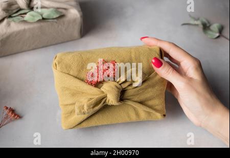 woman holding gift packed in furoshiki style Stock Photo