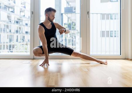Young handsome man practicing yoga at home Stock Photo