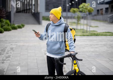 Courier search client place on smartphone in city Stock Photo