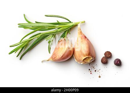 Garlic cloves with roesemary branch and black pepper isolated on white background; top view Stock Photo