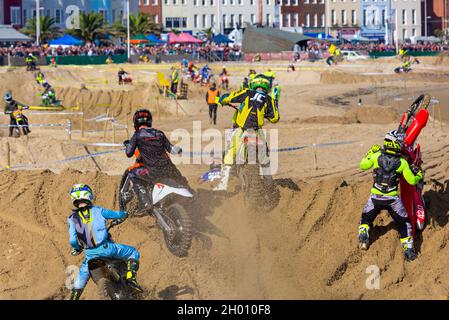 Weymouth, Dorset, UK. 10th October 2021. Thousands of spectators flock to Weymouth to watch the riders compete in the annual motocross racing on Weymouth Beach. About 300 riders race around the obstacle track at speed and with skilful manoeuvring as crowds watch the action, listen to the roar of the engines and the smell of the bikes. . Credit: Carolyn Jenkins/Alamy Live News Stock Photo