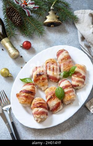Christmas dinner, holiday menu. Baked chicken fillet with ricotta in bacon is served on a festive xmas table. Stock Photo