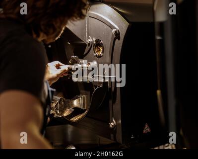 Man using industrial coffee roasting machine at factory Stock Photo