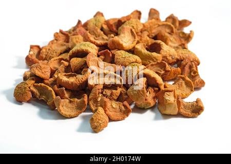 Dried pieces of apples on a white background. Dried apple fruits for making compote. Close-up of sun-dried fruit slices. Stock Photo