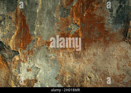 The texture of old crumbling plaster with paint on the wall. Stock Photo