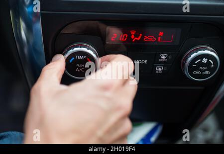 Close up of hand adjusting air conditioning system in car while driving Stock Photo