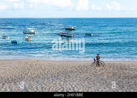 Salvador, Bahia, Brazil - May 30, 2021: Man with his bicycle on the sand of the Rio Vermelho beach on a sunny day. Stock Photo