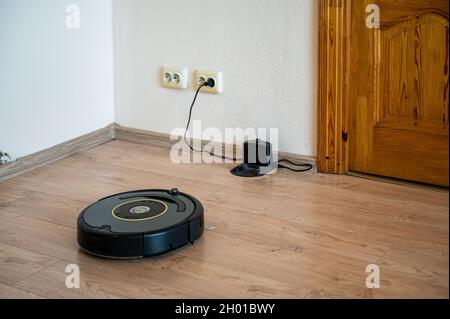 robot vacuum cleaner return to charging at dock in clean room floor Stock Photo