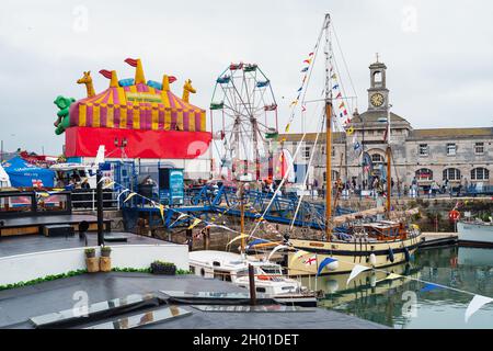 Ramsgate, UK - Sep 26 2021 A fun fair and Our Lizzie boat which is one of the Dunkirk Little Ships, in the habour during the 200 year celebrations of Stock Photo