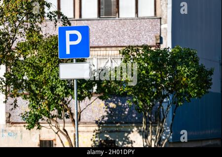 parking road sign with a blank information plate on the background of a residential house, mockup Stock Photo