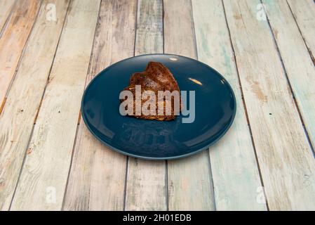 Portion of fruit cake with chocolate on blue plate Stock Photo