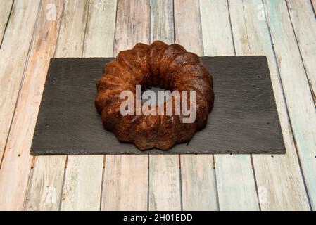 Circular fruit tart sponge cake with chocolate on slate plate Stock Photo