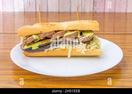 vegetable sandwich with raw mushrooms, roasted aubergines, grated fresh cheese and lettuce with green sauce Stock Photo