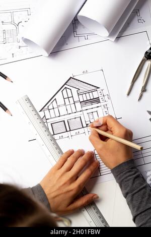 An architect draws a house project. Blueprints. Designer desktop. Engineering construction sketches. Stock Photo