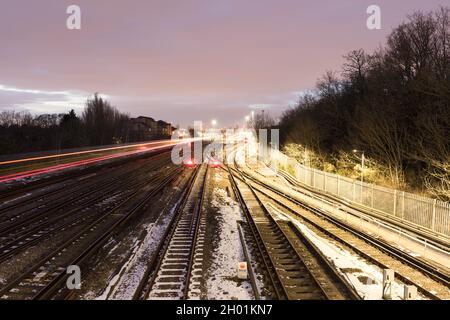 view of central London shining in the distance in cold winter sunset over network railway tracks covered in snow in South London England UK weather Stock Photo