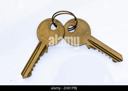 pair of brass yale door keys on a silver metal ring or keyring. keys to the door, two brass yale front door keys, yale style lock keys, yale door lock. Stock Photo
