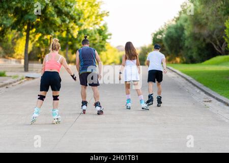 People on their backs skating with inline skates in a path of a park Stock Photo