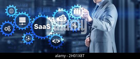 SaaS Software as a Service concept with hand pressing text. Stock Photo
