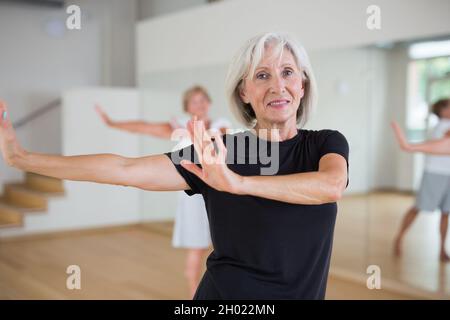Active mature woman learning dynamic dances in choreography class Stock Photo