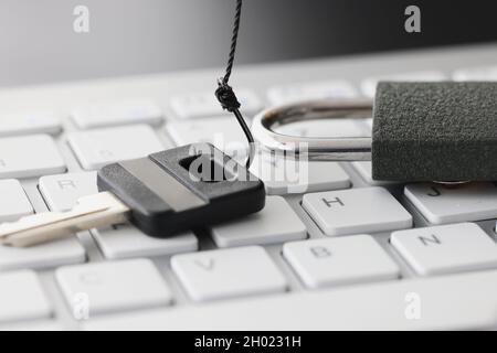 Key and lock on white computer keyboard closeup Stock Photo
