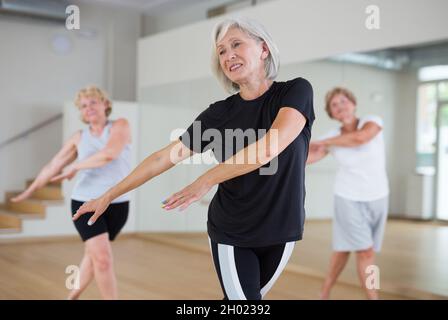 Portrait of mature energetic woman practicing active dancing at a group lesson Stock Photo