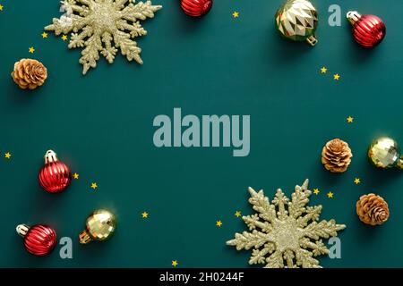 Luxury Christmas flat lay composition. Golden snowflakes, decorations, balls on green background. Stock Photo