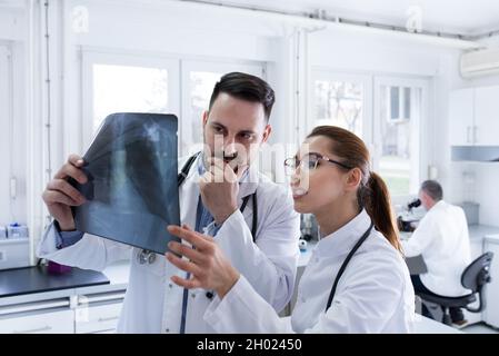 Two doctors male and female looking at x ray at laboratory Stock Photo