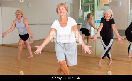 Energetic elderly woman practicing vigorous dance movements Stock Photo