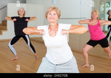 Energetic elderly woman practicing vigorous dance movements Stock Photo