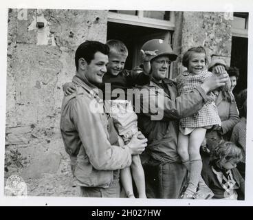 Shortly after the landings on the French coast, two Normandy, France, Yanks make friends with the younger element. In most cases, the Armies of Liberation met with overwhelming receptions from the civilian population 6/9/1944. US Army Stock Photo