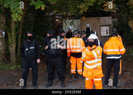 Aylesbury Vale, UK. National Eviction Team (NET) bailiffs block the entrance to the camp. HS2 started evicting anti HS2 protesters holed up in big woodland fortresses at the WAR Against HS2 camp today. The land off the A413 just outside Wendover is owned by Buckinghamshire Council but has been seized by court order by HS2 Ltd. The High Speed Rail 2 rail construction is having a devastating impact upon woodland and wildlife sites in Wendover. Credit: Maureen McLean/Alamy Stock Photo