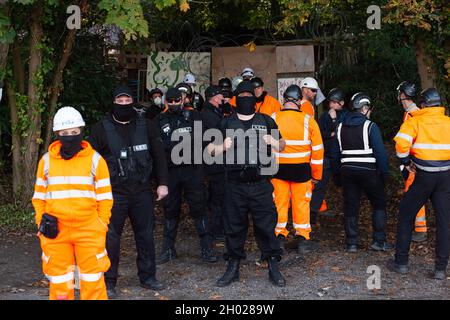 Aylesbury Vale, UK. National Eviction Team (NET) bailiffs block the entrance to the camp. HS2 started evicting anti HS2 protesters holed up in big woodland fortresses at the WAR Against HS2 camp today. The land off the A413 just outside Wendover is owned by Buckinghamshire Council but has been seized by court order by HS2 Ltd. The High Speed Rail 2 rail construction is having a devastating impact upon woodland and wildlife sites in Wendover. Credit: Maureen McLean/Alamy Stock Photo