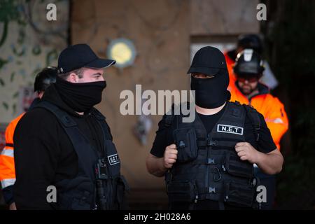 Aylesbury Vale, UK. National Eviction Team (NET) bailiffs block the entrance to the camp. HS2 started evicting anti HS2 protesters holed up in big woodland fortresses at the WAR Against HS2 camp today. The land off the A413 just outside Wendover is owned by Buckinghamshire Council but has been seized by court order by HS2 Ltd. The High Speed Rail 2 rail construction is having a devastating impact upon woodland and wildlife sites in Wendover. Credit: Maureen McLean/Alamy Stock Photo