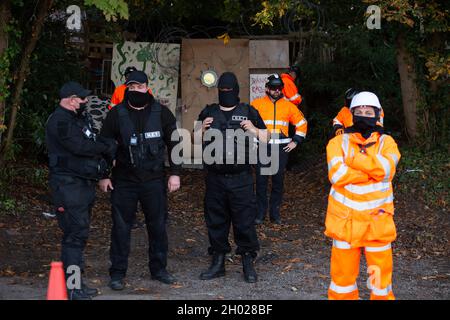 Aylesbury Vale, UK. National Eviction Team (NET) bailiffs block the entrance to the camp. HS2 started evicting anti HS2 protesters holed up in big woodland fortresses at the WAR Against HS2 camp today. The land off the A413 just outside Wendover is owned by Buckinghamshire Council but has been seized by court order by HS2 Ltd. The High Speed Rail 2 rail construction is having a devastating impact upon woodland and wildlife sites in Wendover. Credit: Maureen McLean/Alamy Stock Photo