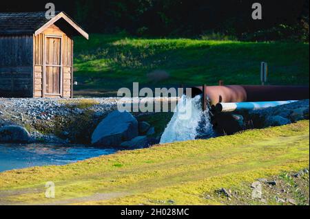 Water spilling from a culvert into a ditch which will flood the cranberry fields before the harvest. Pitt Meadows, B. C., Canada. Stock Photo
