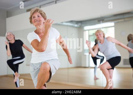 Portrait of mature energetic woman practicing active dancing at a group lesson Stock Photo