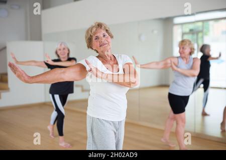 Portrait of mature energetic woman practicing active dancing at a group lesson Stock Photo
