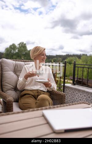 Attractive blonde lady enjoying her breakfast outside Stock Photo