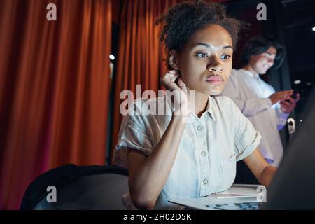 American woman working on laptop on workplace Stock Photo
