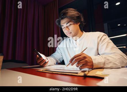 Serious man filling out questionnaire on workplace Stock Photo