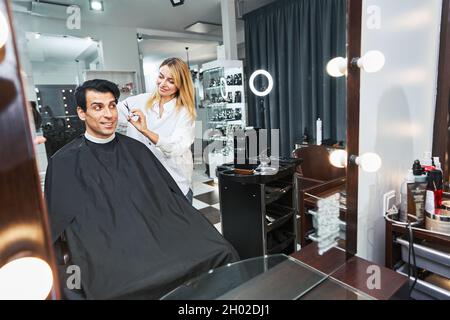 Woman hair stylist making a haircut to customer Stock Photo
