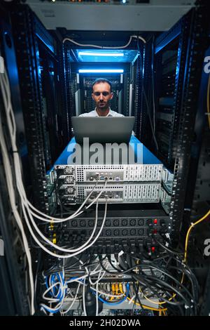 Caucasian data center technician doing security maintenance of server Stock Photo