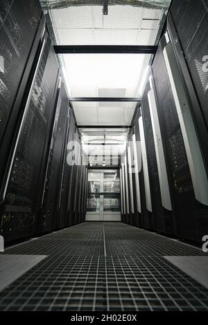 Server racks standing in hallway of data center Stock Photo