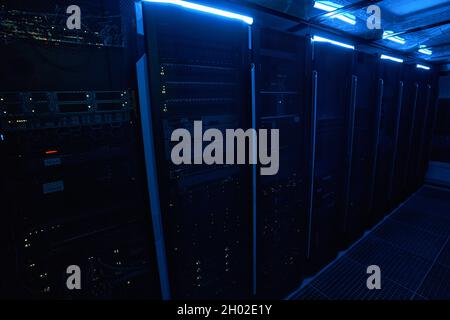 Line of server cabinets maintaining network in data center Stock Photo