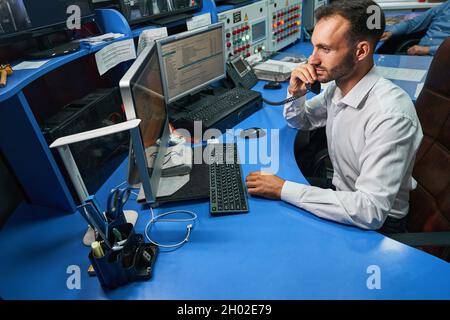 Network administrator speaking on phone while administering data center servers Stock Photo