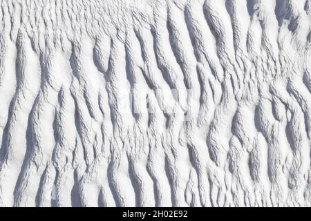 Ribbed abstract texture of Pamukkale calcium travertine in Turkey, asymmetric pattern close-up. Stock Photo