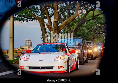 A Chevrolet Corvette is reflected in the driver’s side mirror of a car on Highway 90 during the 25th annual Cruisin’ the Coast antique car show. Stock Photo