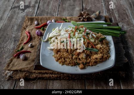 Asian eating food, Mee Grob is an sweet and sour crispy noodles, made from Thai rice noodle with sweet and sour sauce on white plate, Sweet & Sour Cri Stock Photo