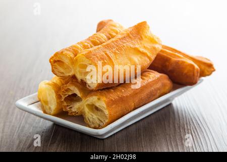 Youtiao (Chinese fried breadstick). Long golden brown deep fried dough strip. Stock Photo